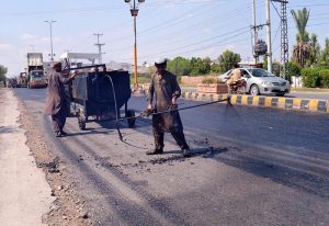 Laborers busy construction work of Lahore road during development work in the city.