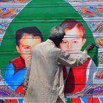 A painter busy in painting on the body of track at his workplace