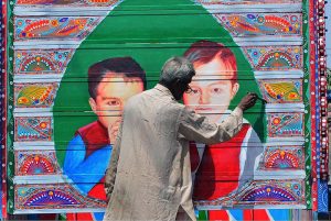 A painter busy in painting on the body of track at his workplace