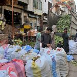 Labourers unloading and packing corns at Vegetable Market.
