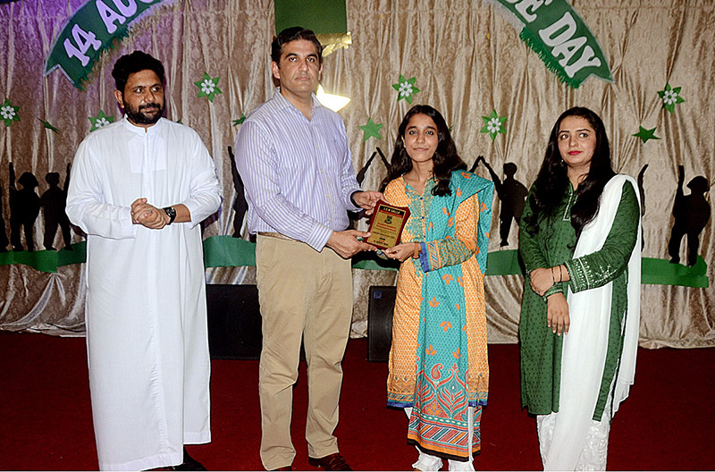 Deputy Commissioner Umar Jahangir giving shield to student during the ceremony at La Salle Higher Secondary School