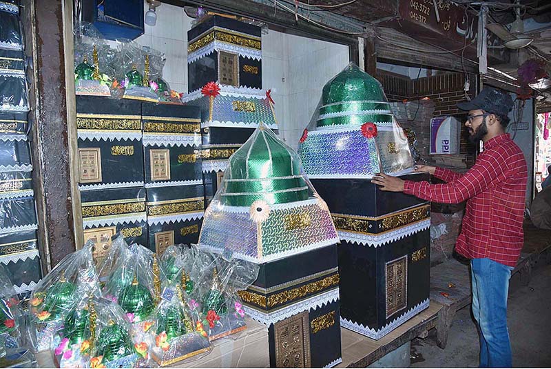 A vendor arranging and displaying Eid Milad-un-Nabi (PBUH) related stuff to attract the customers in the Provincial city.
