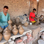 Craftsmen busy in preparing clay made pots at his workplace