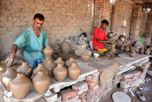 Craftsmen busy in preparing clay made pots at his workplace