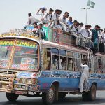 Students are engaging in risky behavior by traveling on the rooftop of a passenger bus, which may cause any mishap and needs the attention of concerned authorities