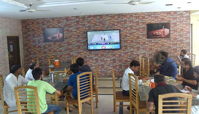 People are watching Pakistan India match in a cafeteria