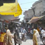 Customers are busy in purchasing stuff from vendors at a Local Market.