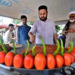 A vendor preparing traditional food item to attract customers at his roadside setup in the Federal Capital