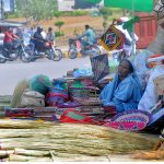 A lady vendor displaying handmade household items while waiting for customers near Ghanta Ghar Chowk.