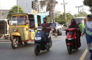  Woman riding Scooty on the way towards her destination.
