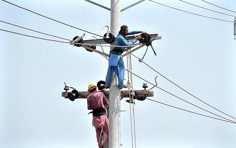 FESCO worker repairing electricity line on an electric pole