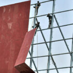 Workers busy in new signboard installation on the building at IJP road.