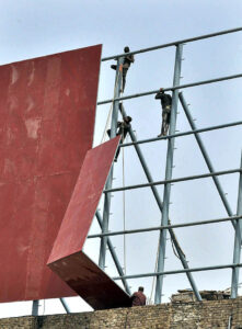 Workers busy in new signboard installation on the building at IJP road.