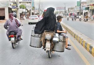 Family sitting on milk pots on the rear seat of a motorcycle in a dangerous way may cause any mishap and need the attention of concerned authorities.