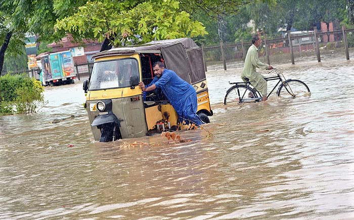 Vehicles passing through the accumulated water after heavy rain that experienced in the Provincial Capital.