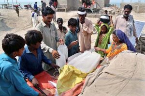 People purchasing ice from roadside vendor at Jamshoro area. 