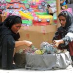 A woman selecting and purchasing bangles from roadside woman vendor at Shamsabad