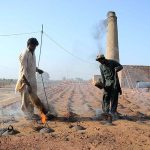 Labourers are adding coal in a kiln as fuel for the preparation of bricks at a local bricks kiln.