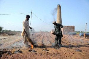 Labourers are adding coal in a kiln as fuel for the preparation of bricks at a local bricks kiln.