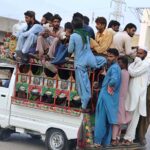 A large number of passengers traveling on the rooftop of Suzuki van in risky way may cause any mishap and needs the attention of concerned authorities at Hala Naka Road.