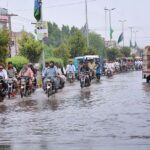 A view of vehicles passing through stagnant rain water at Millat road