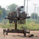 Worker preparing iron stand for solar panel