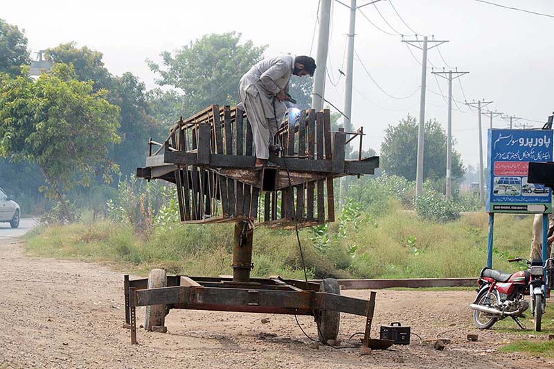 Worker preparing iron stand for solar panel