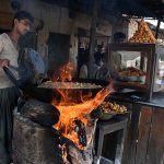 A vendor busy in preparing traditional food item (Pakorey) at Hatti Village Road.