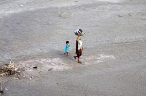 A woman on the way after washing the crockery at bank of Indus River. 