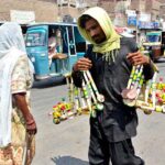 A street vendor on the way while carrying and displaying the wooden toys to attract the customers at Pathan Colony
