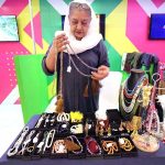 Woman displaying jewellery on stall during 3 Days Rural Youth Summit at local hotel.