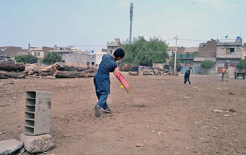 Boys are playing cricket at the wooden market.
