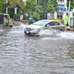 Vehicles are passing through rain water accumulated on road after heavy rain in the Provincial city