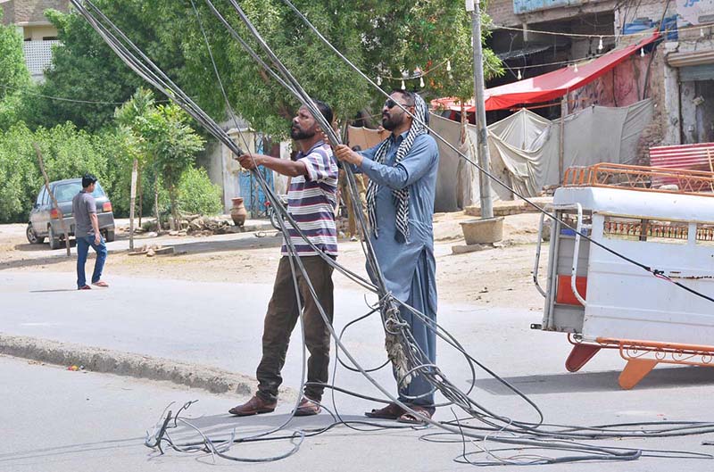 A lineman busy in cutting the illegal line of electricity during crackdown against illegal connections in the city