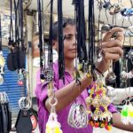 A young vendor displaying the artificial jewelry and other stuff at Bakrani Road.