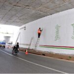 A Painter busy making different designs on the wall of Rawal underpass.