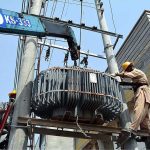 WAPDA staffers busy in installing power transformer on electric pole at Mohamdi Colony