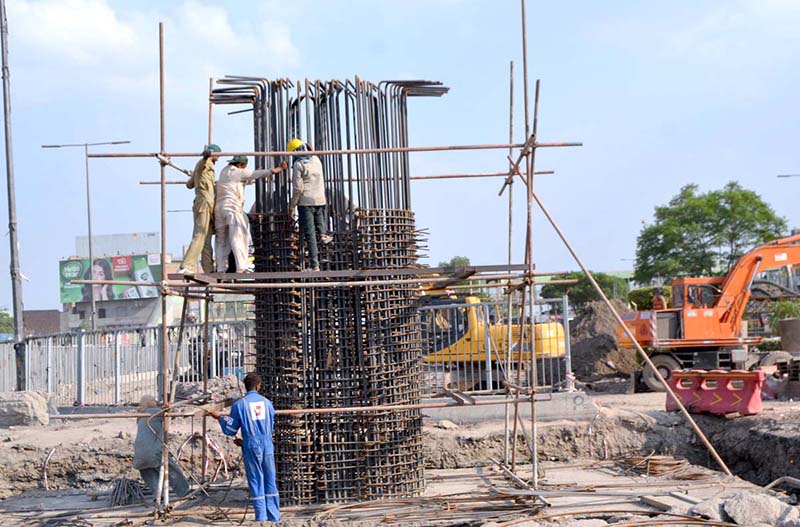 Workers engaged in construction work on six lane overhead bridge of Shahdara N-5 Crossing near Imamia Colony