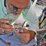 Technician reporting wrist watch at his workplace at Baara bazar.