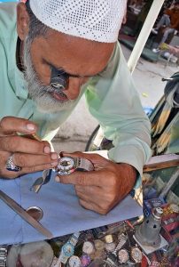 Technician reporting wrist watch at his workplace at Baara bazar. 