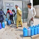 People busy in filling their water cans with clean drinking water from filtration plant