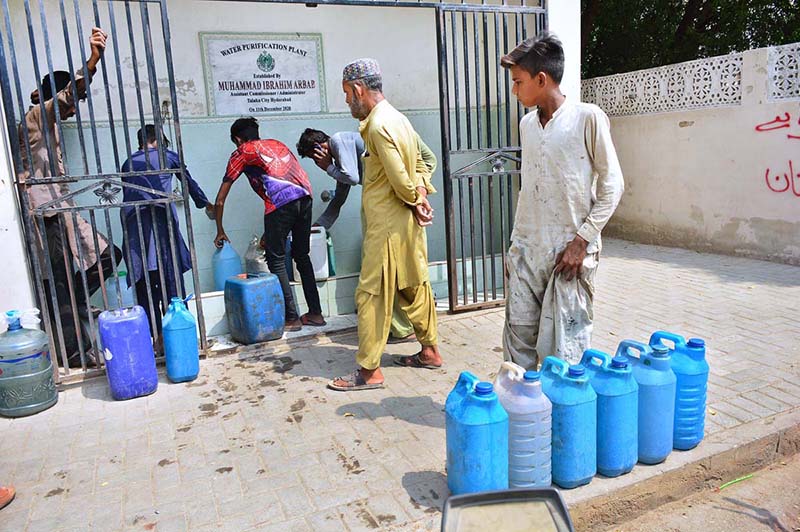 People busy in filling their water cans with clean drinking water from filtration plant