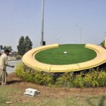 CDA worker busy in watering plants on greenbelt near H-9 flyover