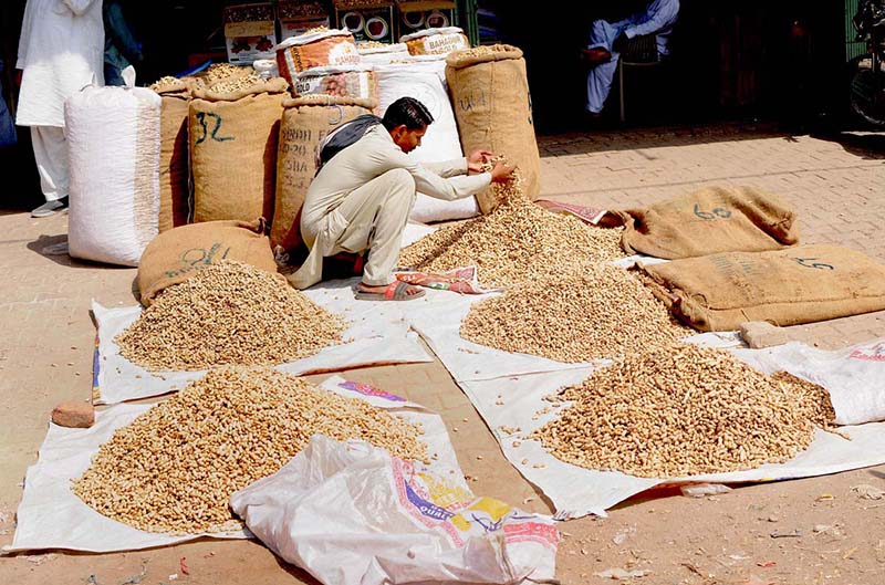 A shopkeeper displays peanuts to attract customers at the Grain Market