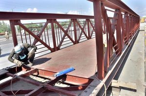  Worker busy in fixing the overhead pedestrian bridge at IJP road. 