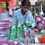 A vendor arranging and displaying Eid Milad-un-Nabi (PBUH) related stuff to attract the customer at -Gambat Road.