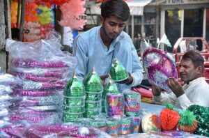  A vendor arranging and displaying Eid Milad-un-Nabi (PBUH) related stuff to attract the customer at -Gambat Road. 