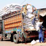 Labourers are unloading sacks of rice from delivery truck at the Grain Market