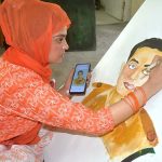 Student giving final touch to her painting regarding Defence day at Bab-e-Pakistan Walton Road