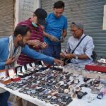 People are looking to buy watches at roadside in the city.